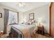 A cozy bedroom with neutral walls, complemented by a ceiling fan and a sunlit window with decorative curtains at 1027 Plum St # 39, Brownsburg, IN 46112