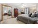 A well lit bedroom with neutral walls, ceiling fan, a mirrored closet, and a dresser with built in TV at 1027 Plum St # 39, Brownsburg, IN 46112