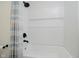 Bright white tiled bathtub and shower feature black fixtures and a decorative shower curtain at 1038 W 33Rd St, Indianapolis, IN 46208