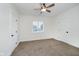 Spacious bedroom with neutral carpet, a ceiling fan, and bright light from the window at 1038 W 33Rd St, Indianapolis, IN 46208
