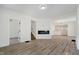 Open living area featuring wood-look floors, recessed lighting, and modern electric fireplace at 1038 W 33Rd St, Indianapolis, IN 46208