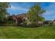Spacious backyard of a brick home with a lush green lawn and mature landscaping at 10471 Winghaven Dr, Noblesville, IN 46060