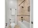 Bathroom featuring a tub with tiled walls, bronze fixtures, decorative mosaic, and a white toilet at 10471 Winghaven Dr, Noblesville, IN 46060