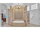 A luxurious bathroom showcases a standalone tub with decorative tile and a chandelier above at 10471 Winghaven Dr, Noblesville, IN 46060
