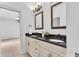 Bathroom showcasing double sinks, black granite countertops, and vintage mirrors at 10471 Winghaven Dr, Noblesville, IN 46060