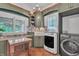 Laundry area with green cabinets, counter space, undermount sink, and modern washer and dryer at 10471 Winghaven Dr, Noblesville, IN 46060