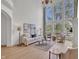 Bright living room featuring a soaring two-story window, fireplace, and hardwood flooring at 10471 Winghaven Dr, Noblesville, IN 46060