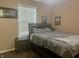 Neutral bedroom featuring a queen-size bed, a window with blinds, and framed posters at 108 Meadowview Dr, Mooresville, IN 46158