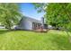 Backyard features a well-maintained lawn, a deck with wooden railings, and mature trees, offering a private outdoor space at 11218 Baycreek Dr, Indianapolis, IN 46236