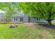 The backyard offers a peaceful retreat with a fire pit, mature trees, and a wooden deck accessible through sliding glass doors at 11218 Baycreek Dr, Indianapolis, IN 46236