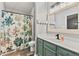 Bathroom with a floral shower curtain, vanity with modern fixtures, and storage at 11218 Baycreek Dr, Indianapolis, IN 46236