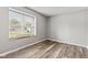 Bright bedroom featuring a large window with blinds and a window seat with stylish laminate wood flooring at 11218 Baycreek Dr, Indianapolis, IN 46236