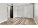 Spacious bedroom with light laminate floors, a closet with double doors, and a second black door at 11218 Baycreek Dr, Indianapolis, IN 46236