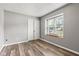 Bright bedroom featuring a large window with blinds and a window seat with stylish laminate wood flooring at 11218 Baycreek Dr, Indianapolis, IN 46236