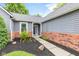 Inviting front entrance with landscaped flower bed and stylish front door, brick, and light gray siding at 11218 Baycreek Dr, Indianapolis, IN 46236