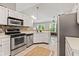Kitchen featuring stainless appliances, tiled backsplash, and white cabinets with a skylight at 11218 Baycreek Dr, Indianapolis, IN 46236