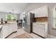 Well-lit kitchen featuring white cabinetry, stainless steel appliances, and a view of the office space at 11218 Baycreek Dr, Indianapolis, IN 46236