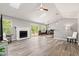 Open-concept living room with vaulted ceiling, wood floors, modern lighting, and a cozy fireplace at 11218 Baycreek Dr, Indianapolis, IN 46236