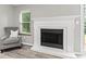 Bright living room featuring a traditional fireplace, hardwood floors, and a comfortable armchair at 11218 Baycreek Dr, Indianapolis, IN 46236