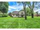 Lush backyard featuring a house with a stone foundation, bordered by mature trees at 116 Bennington Rd, Indianapolis, IN 46227