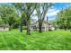 Expansive backyard with mature trees surrounding a house with a stone foundation at 116 Bennington Rd, Indianapolis, IN 46227