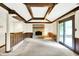 Finished basement with a stone fireplace, wood paneled walls, wood beams and sliding glass doors at 116 Bennington Rd, Indianapolis, IN 46227