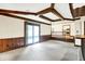 Finished basement with a stone fireplace, wood paneled walls, wood beams and sliding glass doors at 116 Bennington Rd, Indianapolis, IN 46227