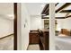 Basement bar area with wood cabinets and beams and a view of the stone fireplace at 116 Bennington Rd, Indianapolis, IN 46227