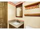 Bathroom with wooden vanity, sink, mirror, toilet and wallpaper at 116 Bennington Rd, Indianapolis, IN 46227