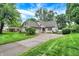 Inviting home showcases manicured landscaping, a circular driveway, and charming architectural details at 116 Bennington Rd, Indianapolis, IN 46227