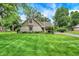 Beautifully landscaped front yard with lush green grass and mature trees enhancing the home's curb appeal at 116 Bennington Rd, Indianapolis, IN 46227