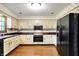 Traditional eat-in kitchen with wood cabinets, black appliances, and wooden floors at 116 Bennington Rd, Indianapolis, IN 46227