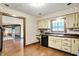 Traditional eat-in kitchen with wood cabinets, black appliances, and wooden floors at 116 Bennington Rd, Indianapolis, IN 46227