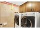Laundry room with washer and dryer, wooden cabinets and wallpaper at 116 Bennington Rd, Indianapolis, IN 46227