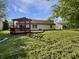 Lush backyard featuring a wooden deck with a pergola, with green grass and partial fencing at 11722 Hartland Dr, Indianapolis, IN 46229