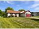 Beautiful single-story home with a well-manicured lawn and a red garage door at 11722 Hartland Dr, Indianapolis, IN 46229