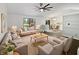 Comfortable living room with a large window, ceiling fan, and modern decor, flowing into the dining area at 11722 Hartland Dr, Indianapolis, IN 46229