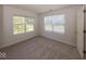 Bedroom featuring neutral carpet, two large windows with blinds, and a door, offering a calm retreat at 11830 Sand Creek Blvd, Fishers, IN 46037