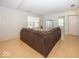Spacious living room with ample natural light, hardwood floors, and a cozy brown sofa at 11830 Sand Creek Blvd, Fishers, IN 46037
