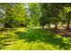Expansive backyard with mature trees, lush lawn, and trampoline, ideal for outdoor activities and relaxation at 1229 Helford Ln, Carmel, IN 46032