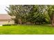 Spacious backyard showcasing lush greenery and a glimpse of the house with a covered deck at 1229 Helford Ln, Carmel, IN 46032