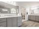 Bathroom with grey vanities, and sinks, wooden floors, and natural light from the window at 1229 Helford Ln, Carmel, IN 46032