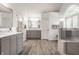 Spacious bathroom featuring double vanity sinks, a walk-in shower, and light gray wooden floors at 1229 Helford Ln, Carmel, IN 46032
