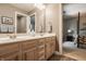 Bathroom featuring a double vanity with and sinks, wood cabinets, and an open door at 1229 Helford Ln, Carmel, IN 46032