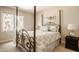 Cozy bedroom with a four-poster bed, soft lighting, and a neutral color palette at 1229 Helford Ln, Carmel, IN 46032
