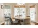 Light-filled dining area with a round wooden table, modern chairs, and large windows at 1229 Helford Ln, Carmel, IN 46032