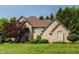 Stunning brick house with lush green lawn, mature trees, and a grand facade at 1229 Helford Ln, Carmel, IN 46032