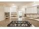 Kitchen island with cooktop and granite countertops, complemented by white cabinets and stainless appliances at 1229 Helford Ln, Carmel, IN 46032
