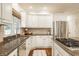 Bright kitchen featuring stainless steel appliances, granite countertops, and white cabinets at 1229 Helford Ln, Carmel, IN 46032