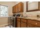 Well-lit laundry room with modern washer/dryer, granite countertops, wooden cabinets, and a large sink at 1229 Helford Ln, Carmel, IN 46032
